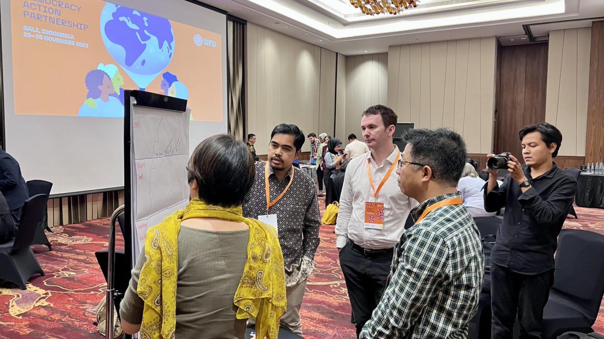 A group of people around a flipchart, discussing