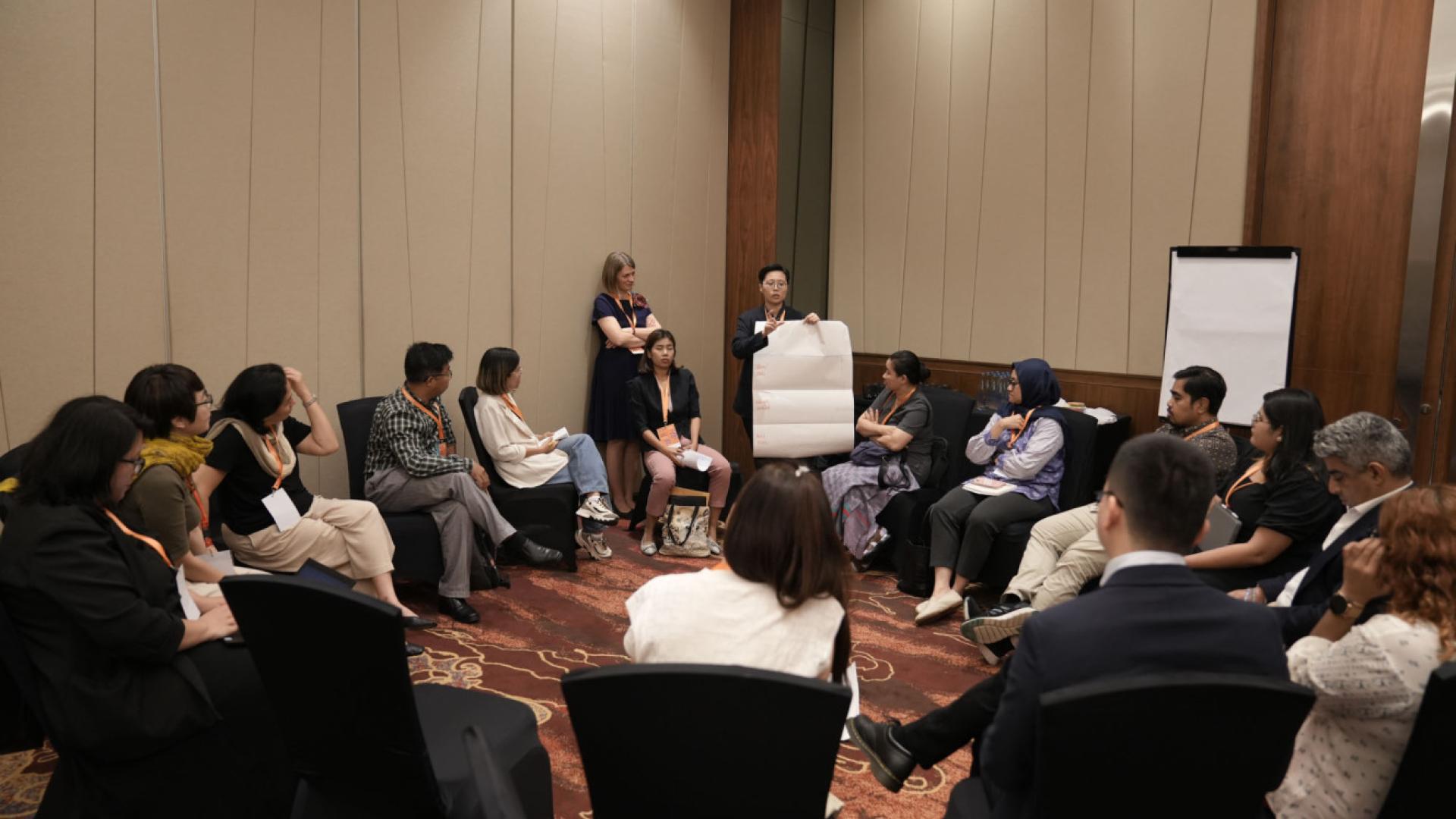 A group of people sit in a circle having a discussion