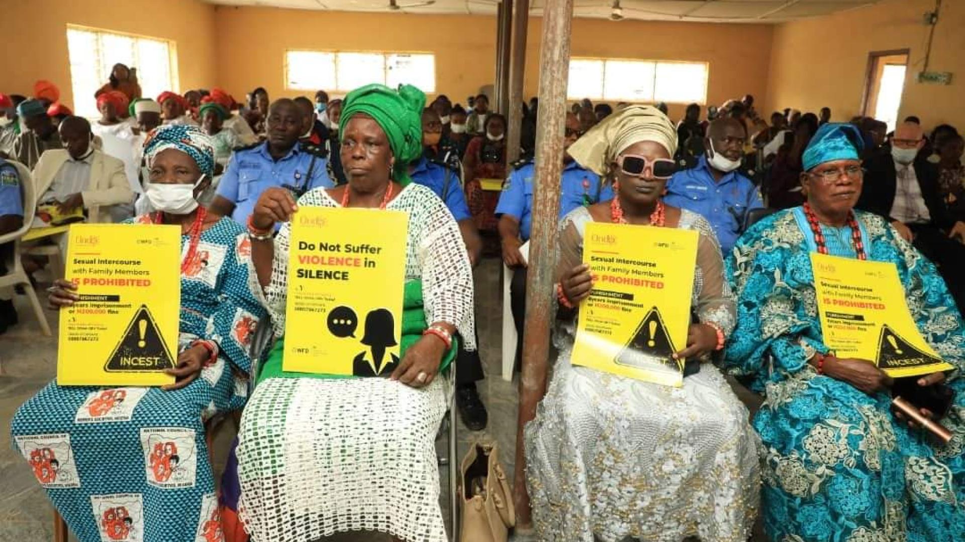 Group of people holding a placard while sitting