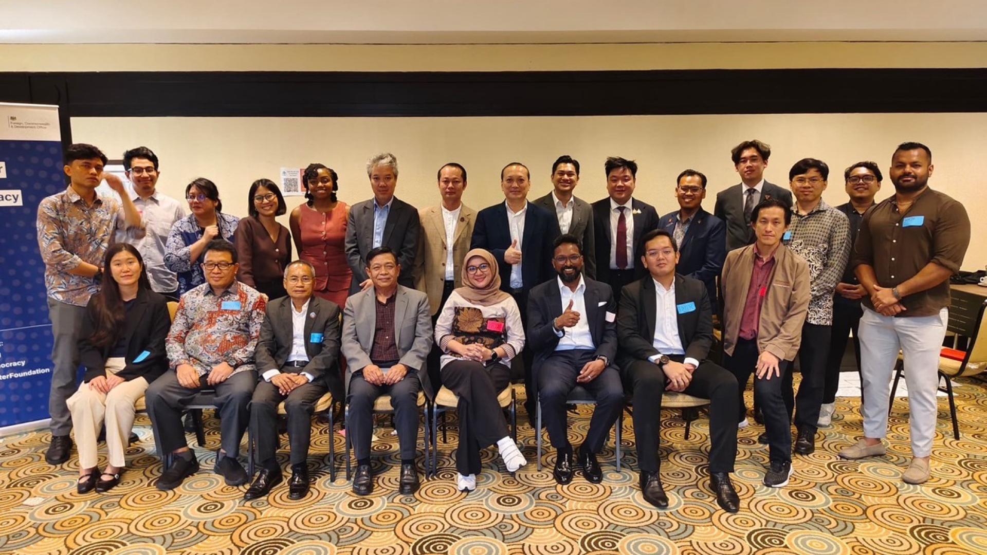 A group photo where a row of men and women are sitting and another row of men and women are standing behind them. 