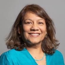 A woman with brown hair and a blue top smiling at the camera