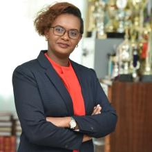 Photo of Dolores Mutheu Kasanga standing and folding arms across chest